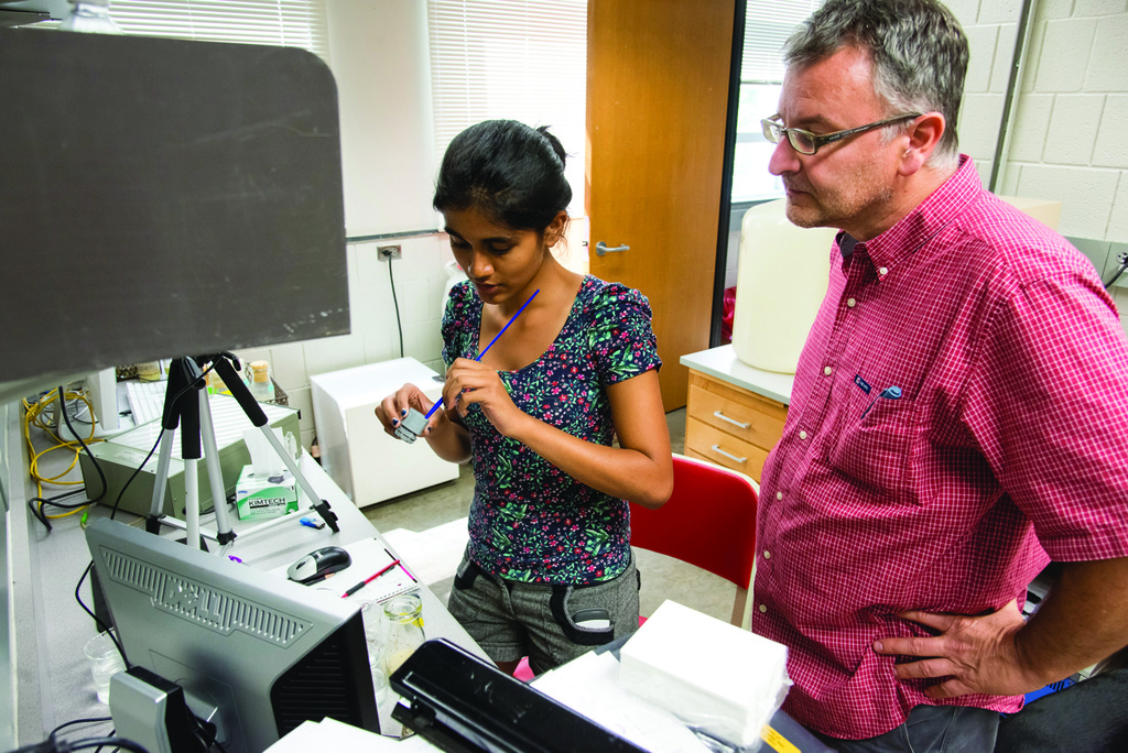 Student working with John Manak in genetics lab.