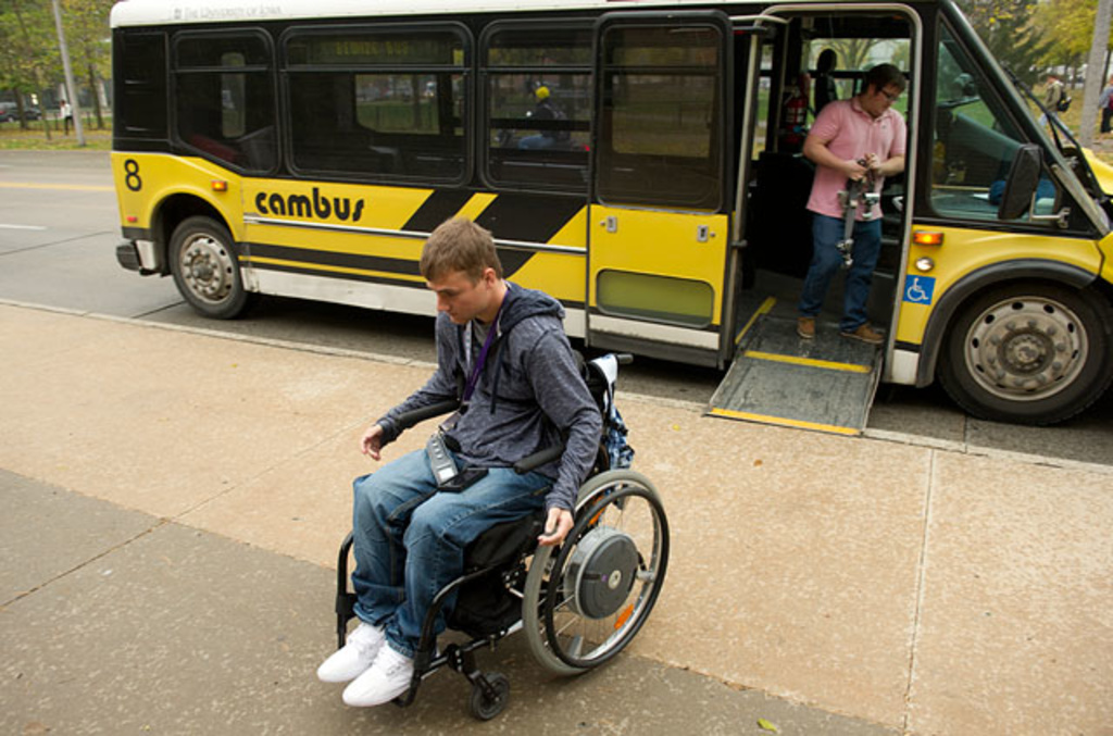 Travis wheels away from the bus he rode to class.