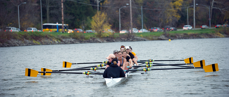 Rowers row on the river.