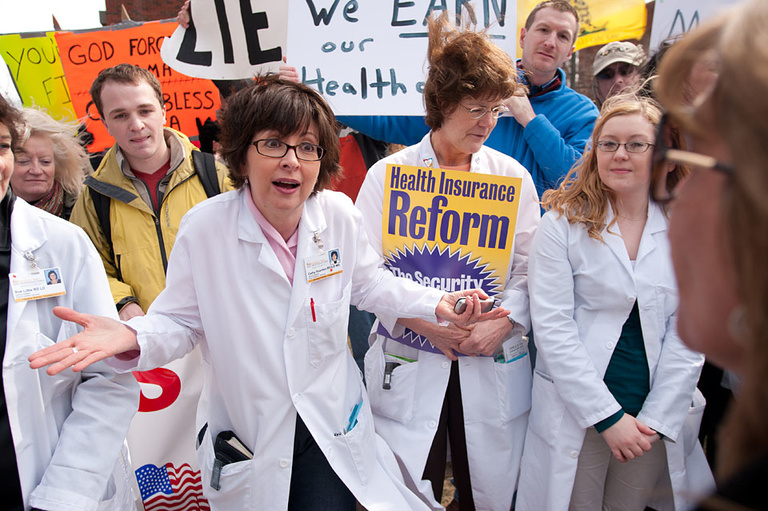 Nurses mix with demonstrators during the president's speech.