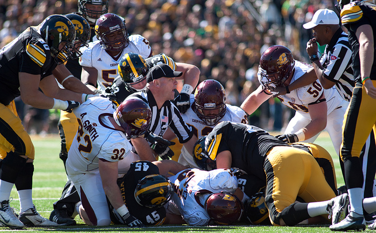 Umpire Ken Zelmanski dives into the pile of players to determine who recovered a fumble.
