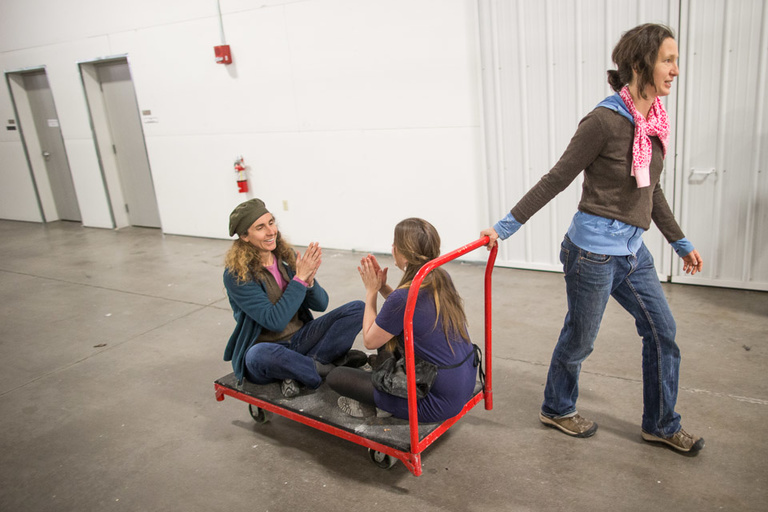 A woman pulls two other people along on a cart during ArtsFest 2013. 