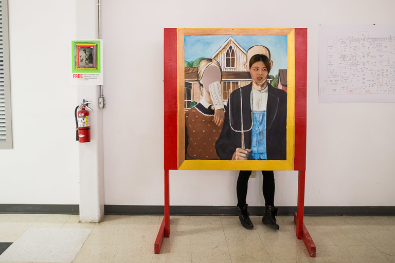 A participant poses behind a replica of Grant Wood's "American Gothic" during ArtsFest 2013.