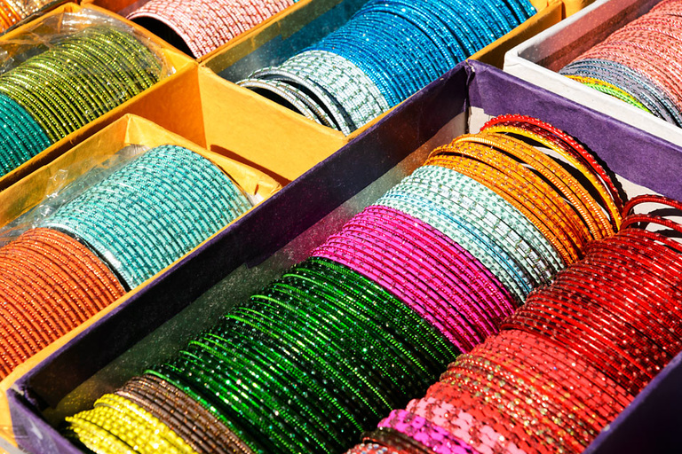 Colorful Indian bracelets line a table.