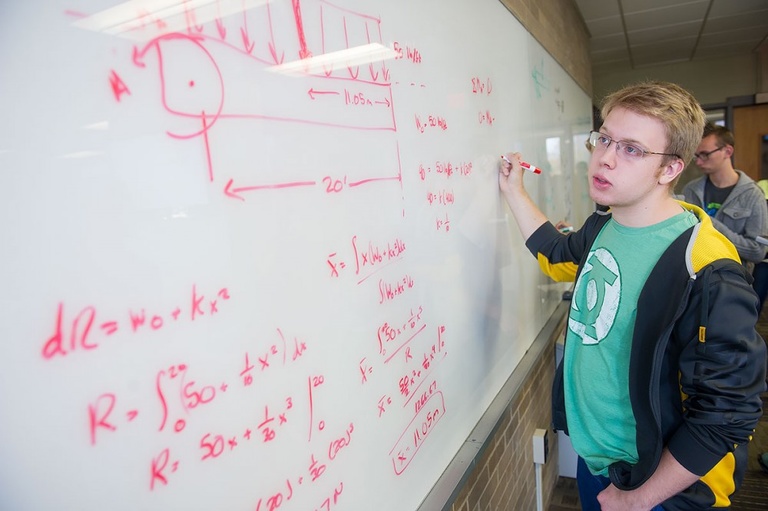 Student using whiteboard to work on engineering problem