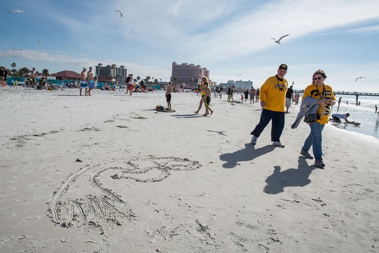 Fans drawing a Tigerhawk in the sand.
