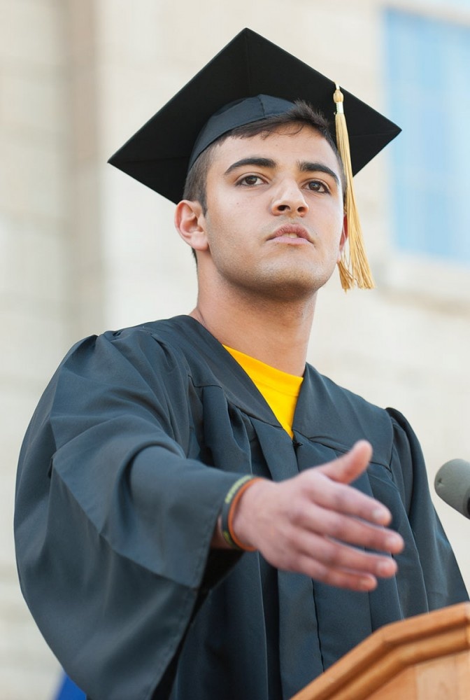 Man in cap and gown at podium.