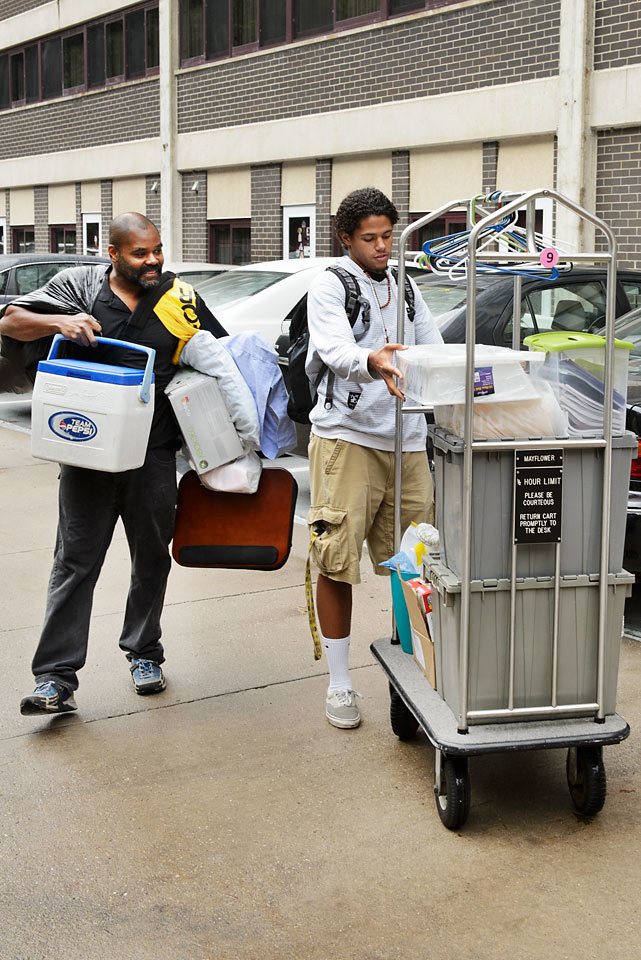 A collage student and parent move belongings into Mayflower Residence Hall. 