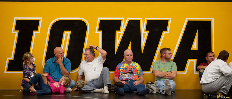 Fans sit in front of the "IOWA" sign