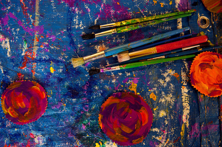 Paint brushes on a colorful palette.