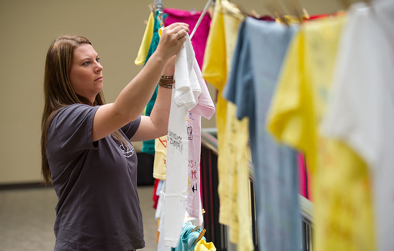 Erin Corman hangs a shirt.