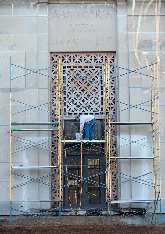 Work on the face of the old art building.