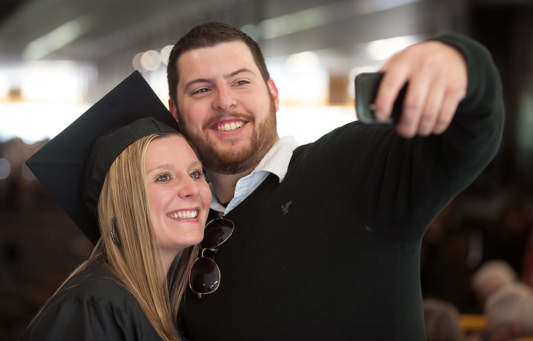 Graduate takes a photo on her phone