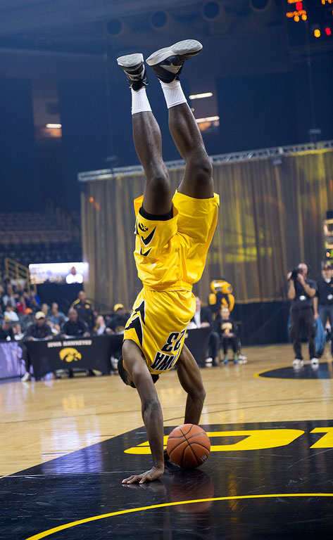 Okey Ukah does a cartwheel as part of his approach to the basket during the dunk contest.
