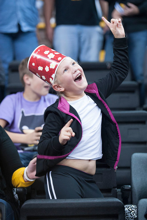 A young fan dances with a popcorn bucket on her head.