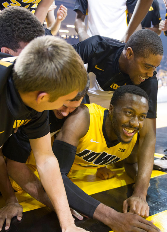 Gabe Olaseni is mobbed by his teammates after throwing down a dunk after jumping from the free throw line. 