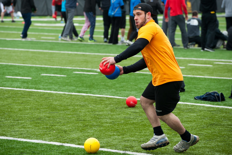 a dodgeball player hold a ball in each hand and prepares to throw