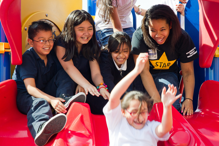 Smiles abound on the playground as Ariel Ferguson and the kids hit the slides on a sunny day.