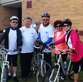 a group of Chinese visitors stand with their bikes