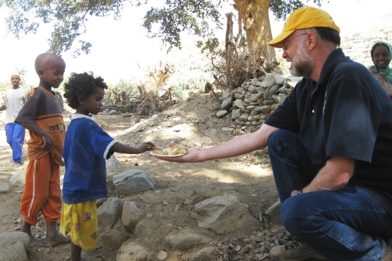 McMullen offering food to a young child