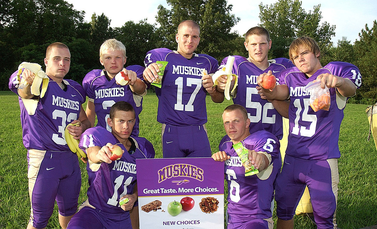 football team holding healthy food items