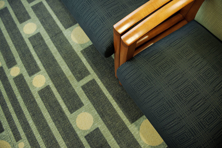 A detail of carpeting and upholstered chair fabric.