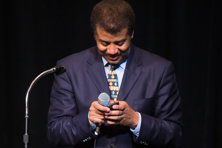 A man looking intently at his cell phone.