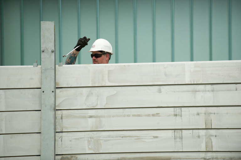 Workman adds a layer to a removable flood wall.