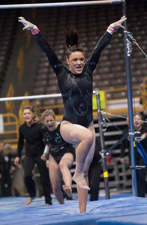 Iowa gymnast competing in the uneven parallel bars.