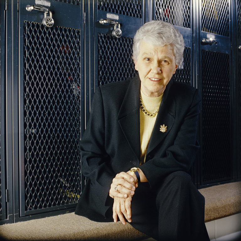 Dr. Christine Grant poses in a locker room.