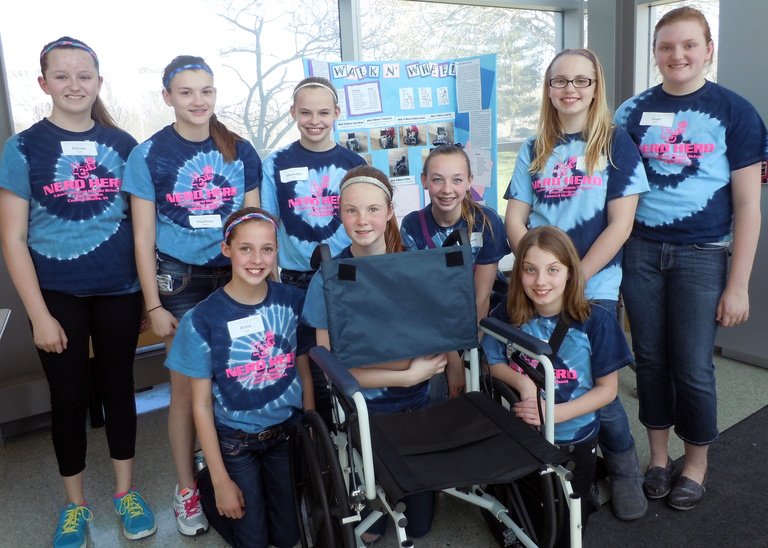 A team of nine girls from Titan Hill Intermediate School in Council Bluffs pose with their 2013 award-winning invention, the Walk n' Wheel.