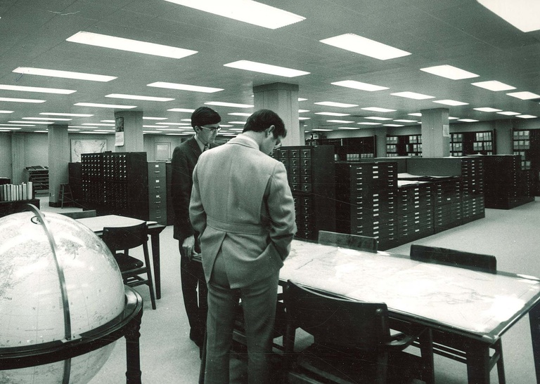 Photo of library patrons viewing maps