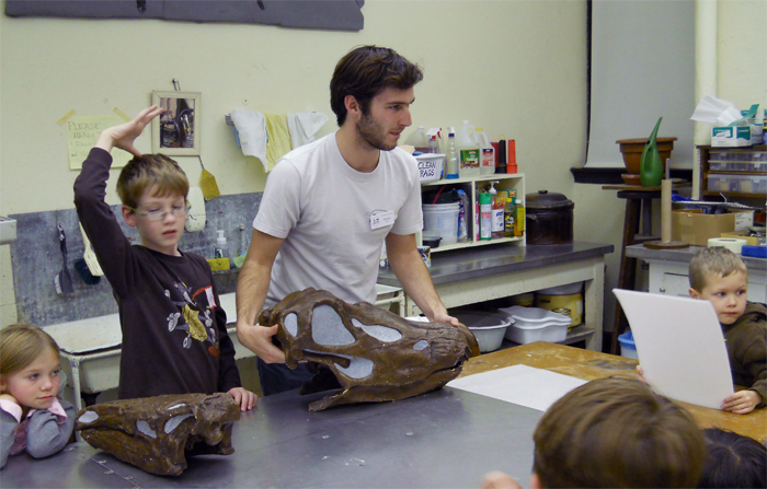 Museum studies certificate student Andrew Blodgett teaches local kids about dinosaurs at the University of Iowa Museum of Natural History. 