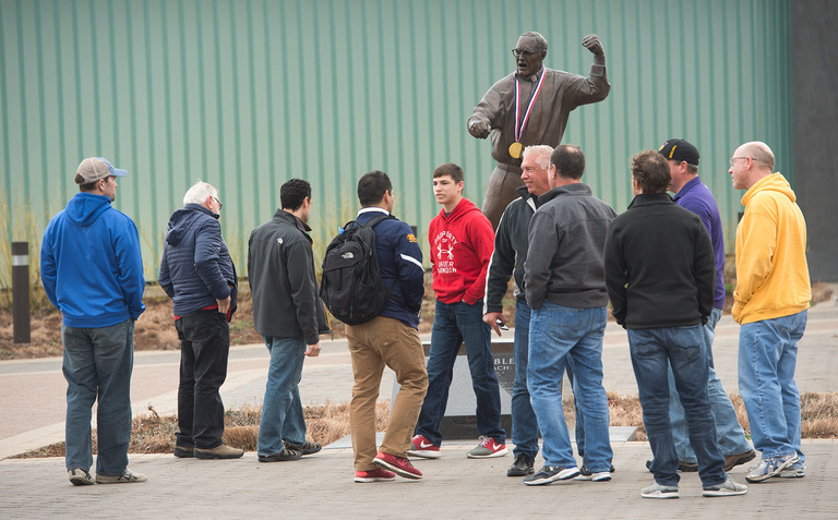 People congregate around the Dan Gable statue outside of Carver Hawkeye Arena.