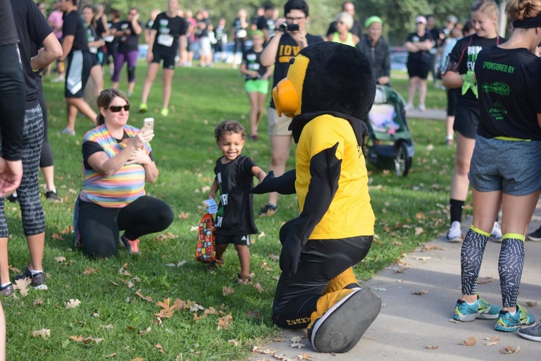 Herky kneeling down, interacting with child
