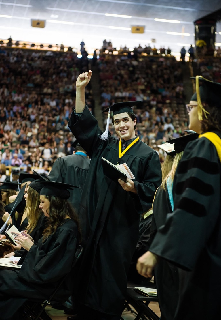 Graduating student celebrates after receiving his diploma.