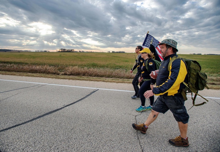 Participants of the UIVA's Game Ball Ruck march along Highway 12 in Minnesota on Tuesday, Nov. 10.  UI Veterans and local volunteers will march 280 miles from Minneapolis to Kinnick Stadium throughout the week to raise awareness for veteran suicide.