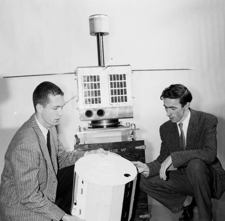 Don Gurnett and Brian O'Brien hold a model of the Injun 1 spacecraft in 1961. The Injun 2 spacecraft can be seen in the background.
