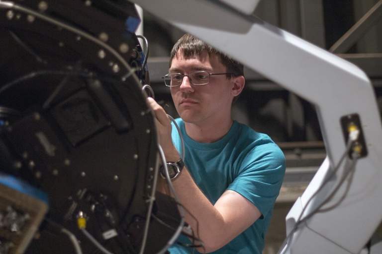 Graduate student Dominic Ludovici works on a part of the telescope.
