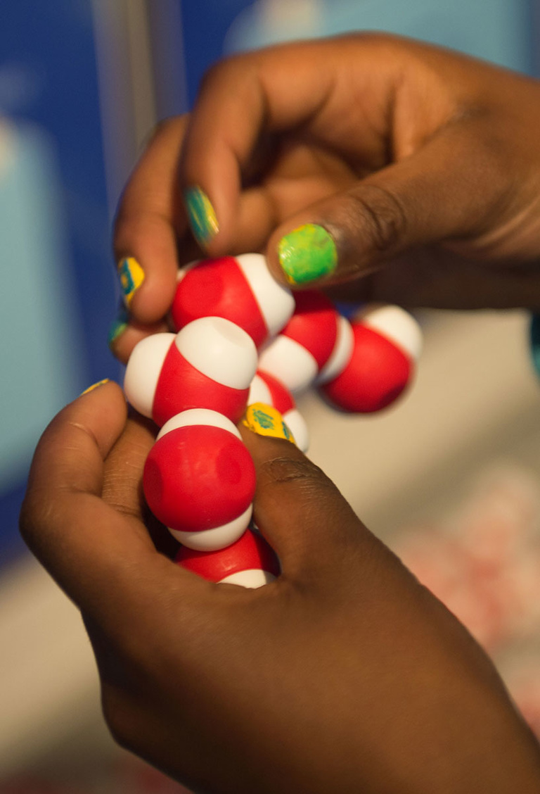 A student plays with magnetic beads that represent water molecules at the UI Mobile Museumm.