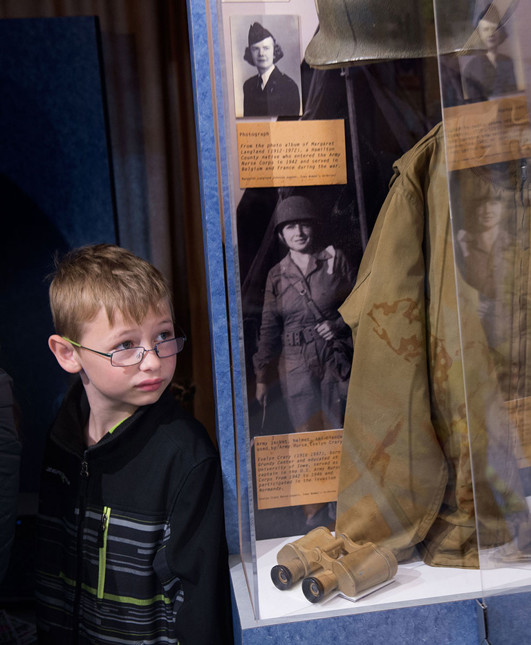 A Lucas student looks at a uniform in a display case of World War II memorabilia in the Mobile Museum.