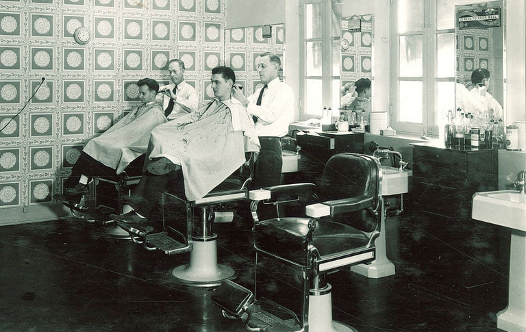 black-and-white image of men getting haircuts in Quadrangle barber shop