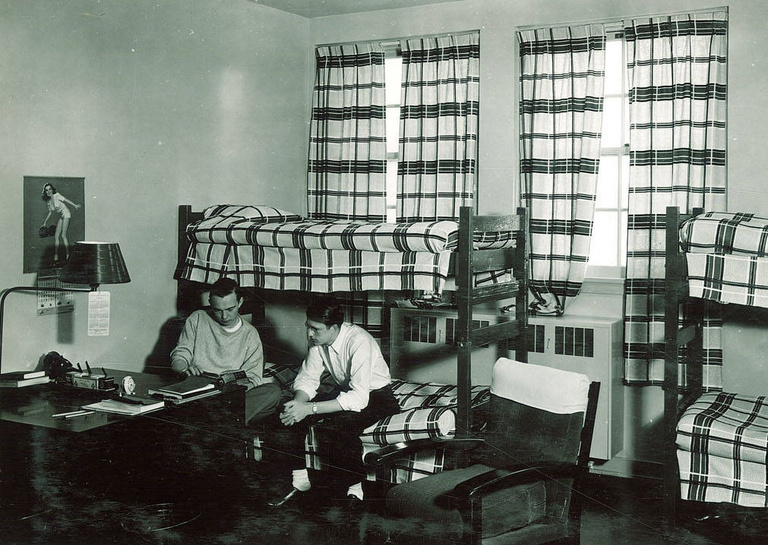 black-and-white image of two men seated in Quadrangle room