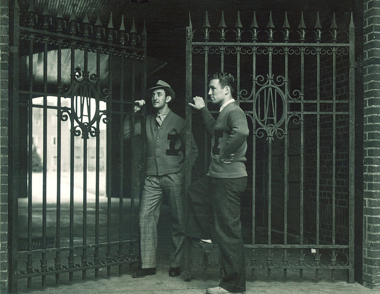 black-and-white image of men standing at Quadrangle gate