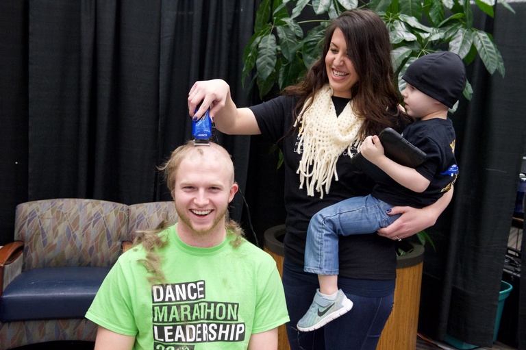 man smiles after having his head shaved