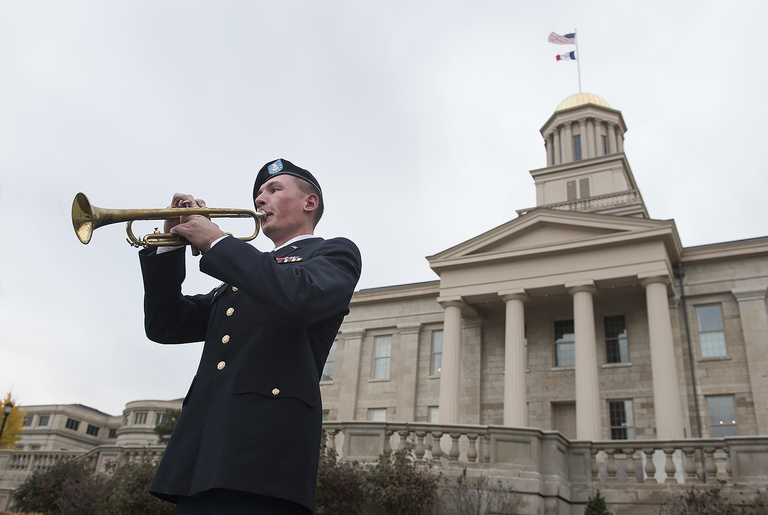 Iowa Army ROTC Cadet Isaac Anderson plays reveille as part of the University of Iowa Veterans Association's opening ceremony on Veterans Day.