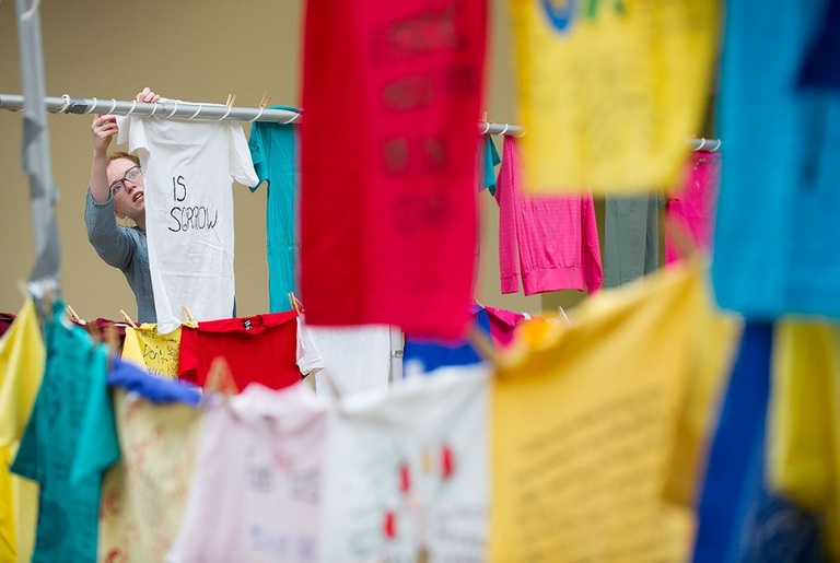 Clothesline project t-shirts hanging in the Old Capitol Town Center. Photo by Tim Schoon.