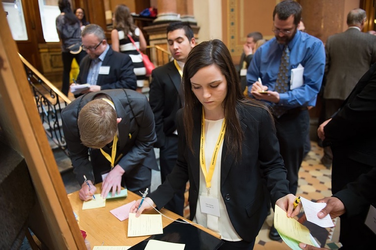 A UI student writes a note to send to a Representative on the House floor.