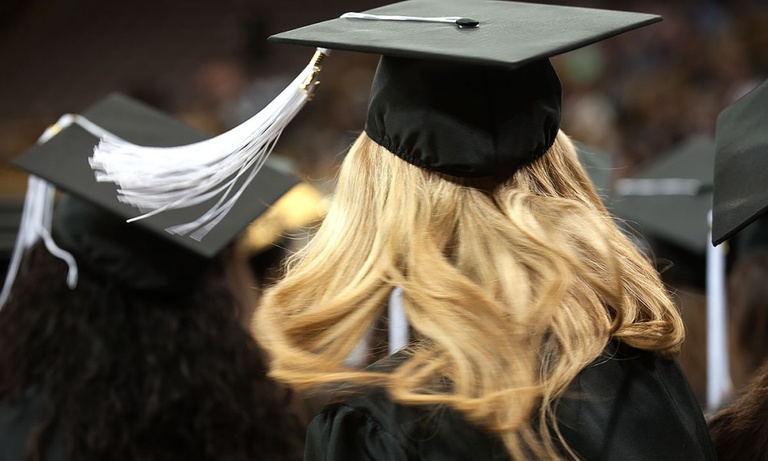 A graduate swings her graduation tassle.