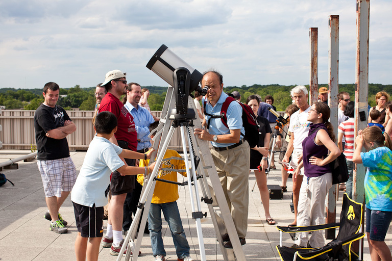 A man looks into a telescope.